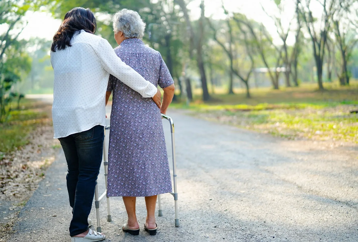 Hilfe und Pflege Asiatische Seniorin oder ältere alte Dame Frau benutzt Rollator mit starker Gesundheit beim Spaziergang im Park in glücklichen frischen Urlaub